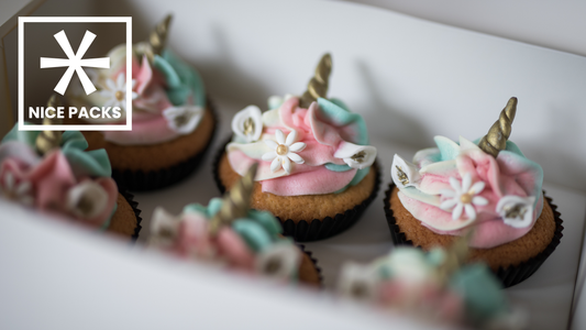 decorated unicorn cupcakes in a box
