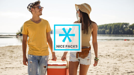Two people carrying an orange cooler on the beach between them