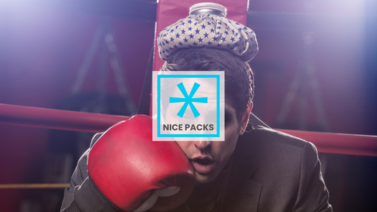 A man with a heat pack on his head in a boxing ring and a glove to his face