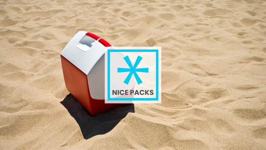 A red and white cooler on beach sand