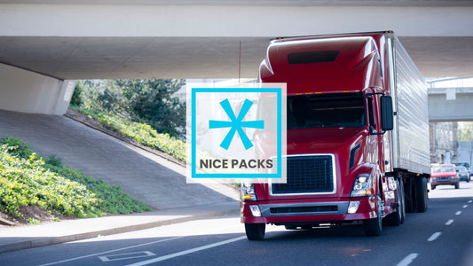 A red 18 wheeler truck on the highway with a fridge on the back as a trailer